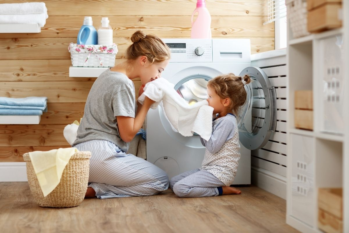 Anya és kislánya a fürdőszobában a friss ruhát szagolja