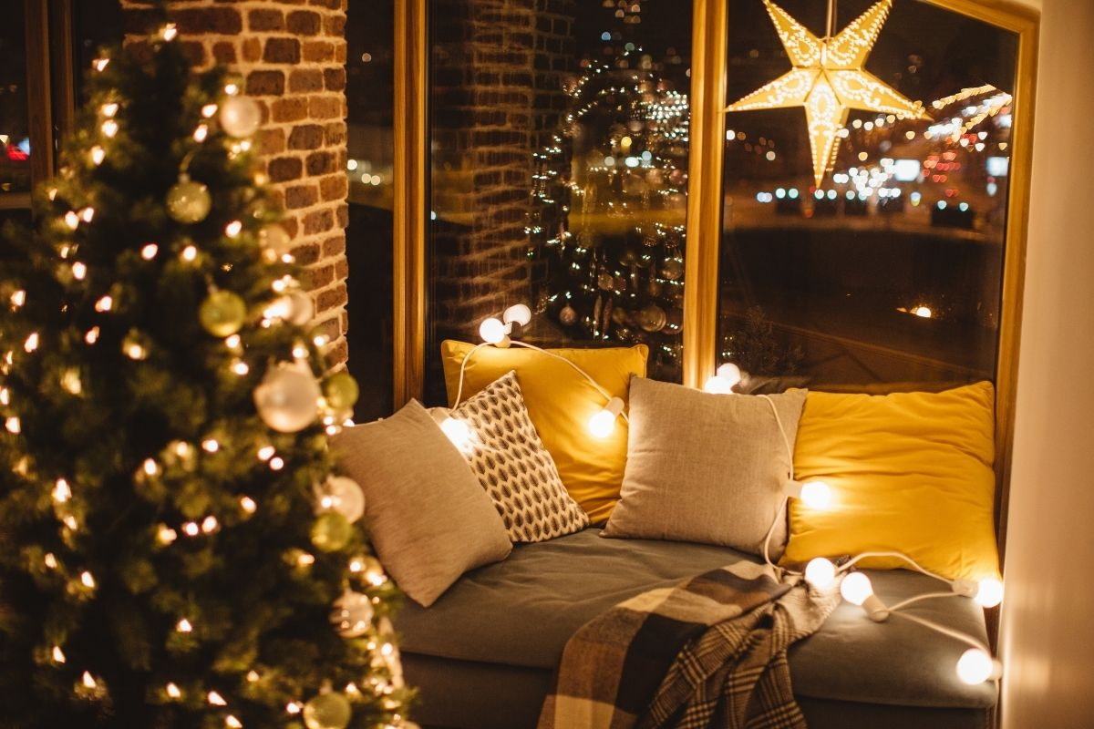 Karácsonyi fények és díszpárnák a kanapén este